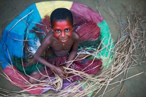 A lesson in basket weaving from a young girl.
