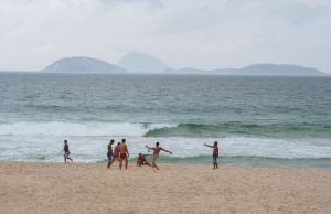 A group of guys juggling a soccer ball on Copacabana Beach