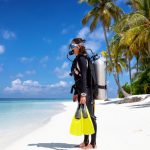 Female,Scuba,Diver,In,Full,Equipment,Stands,On,A,Tropical