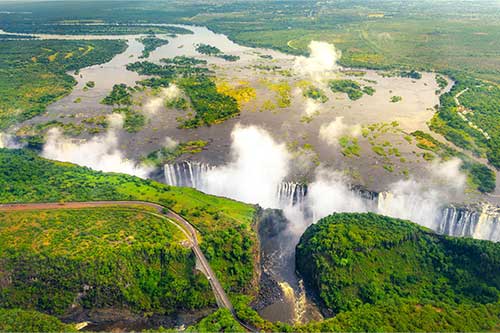 aerial view of victoria falls in southern africa surrounded by the lush green rainforest