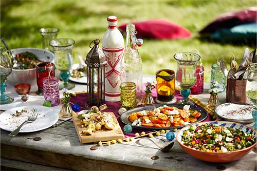 variety of moroccan grilled vegetables and salads with ornate moroccan lanterns and glassware